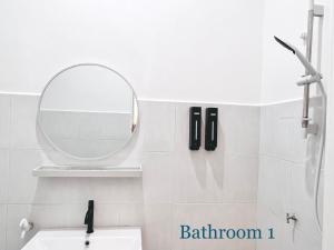 een badkamer met een spiegel en een wastafel bij HeySnowy Netflix & gated and guarded & Lotus in Kluang