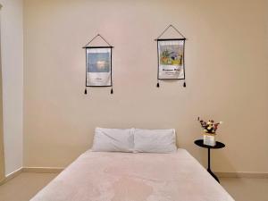 um quarto com uma cama e três estandartes na parede em HeySnowy Netflix & gated and guarded & Lotus em Keluang