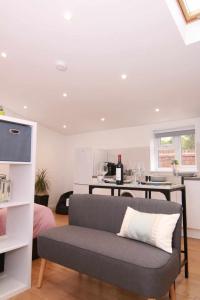 uma sala de estar com um sofá e uma cozinha em Suffolk Cosy Corner with free parking, 10min walking to town centre em Bury Saint Edmunds