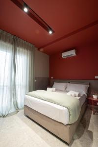una camera da letto con un letto grande e una parete rossa di Mia Suites Porto a Napoli