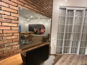 um quarto com uma parede de tijolos com uma mesa e um espelho em City Center Flamingo Suite em Tbilisi