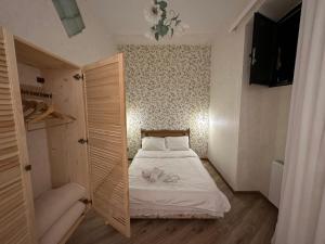 um pequeno quarto com uma cama e um closet em City Center Flamingo Suite em Tbilisi