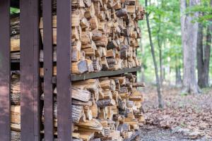 a pile of wood on the side of a building at Modern Cabin w/Hot Tub & Fire Pit! in Hedgesville