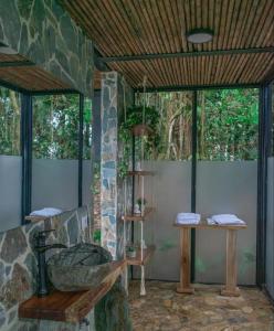 baño con pared de piedra y lavabo de piedra en GLAMPING ENTRE MONTES Y CAFETALES, en Santuario