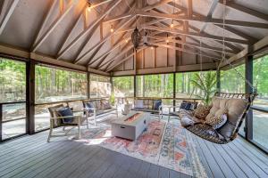 a screened in porch with a hammock and a living room at Modern Cabin w/Hot Tub & Fire Pit! in Hedgesville
