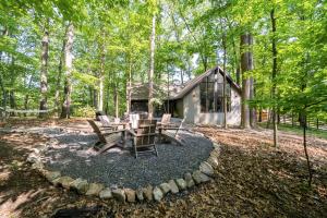 a cabin in the woods with a table and chairs at Modern Cabin w/Hot Tub & Fire Pit! in Hedgesville