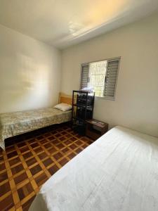 an empty room with two beds and a window at Quarto privativo ótima localização in Sao Paulo