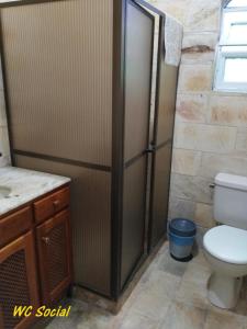 Un baño con inodoro y ducha. en Cabo Frio, a melhor temporada, com menor preço., en Cabo Frío