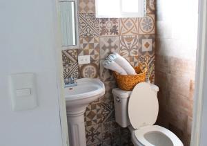 a bathroom with a toilet and a sink at La Casa del Barrio in Monterrey