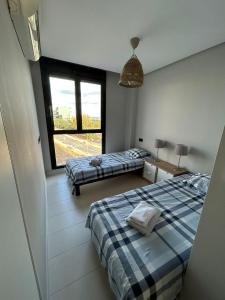 1 dormitorio con 2 camas y ventana grande en Casa Pinto, en Villacosta