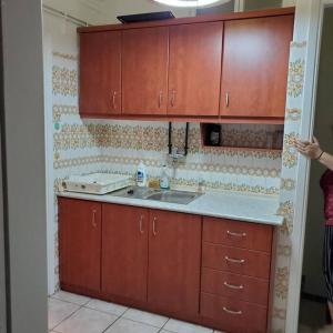 eine Küche mit Holzschränken und einem Waschbecken in der Unterkunft Peace'nQuiet - 200m Nikaia Metro - Detached House with Terrace in Piräus