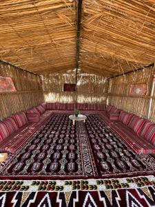 a large room with red chairs and a table in it at Authentic Desert Camp - Al Wasil 