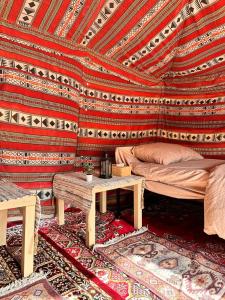 Zimmer mit einem Bett und einem Tisch in der Unterkunft Authentic Desert Camp - Al Wasil 
