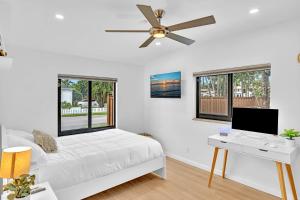 a bedroom with a bed with a desk and a ceiling fan at Tropical Oasis with pool 10 mins airport & 5 mins Beach in Hollywood