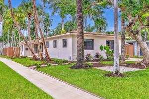 a house with palm trees in front of it at Tropical Oasis with pool 10 mins airport & 5 mins Beach in Hollywood