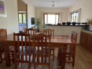 Un comedor con mesa y sillas de madera. en Casa Nice Trancoso, en Trancoso