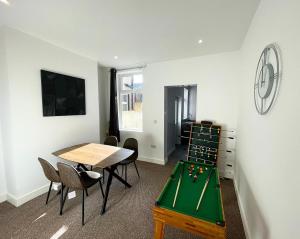 ein Zimmer mit einer Tischtennisplatte und Stühlen in der Unterkunft 38 Gloucester street by Prestige Properties SA in Roose