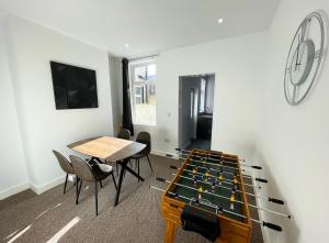 ein Zimmer mit einer Tischtennisplatte und Stühlen in der Unterkunft 38 Gloucester street by Prestige Properties SA in Roose