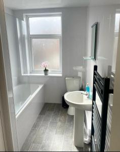 ein Bad mit einem Waschbecken, einem Fenster und einem WC in der Unterkunft 38 Gloucester street by Prestige Properties SA in Roose