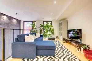 a living room with a blue couch and a tv at Shoreditch 3-Storey Maisonette - by Living Elite Apartments in Shoreditch