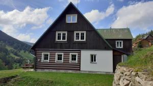 a black and white house on top of a hill at Apartmán U Pekařů in Pec pod Sněžkou