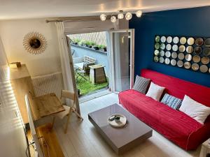 - un salon avec un canapé rouge et une table dans l'établissement Jasmin étoilé duplex avec jardin 15 min de Paris, à Alfortville