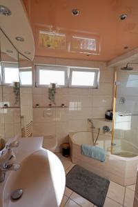 a bathroom with a tub and a shower and a sink at Tolle Wohnung mit Panoramablick in Weinheim