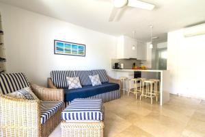 sala de estar con 2 sofás y cocina en Apartamento junto a la playa en San Bartolomé