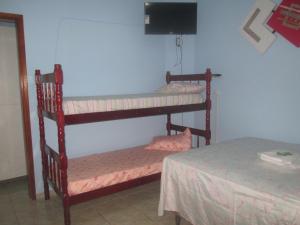 Zimmer mit 2 Etagenbetten und einem Tisch in der Unterkunft Recanto das Rosas in Poços de Caldas