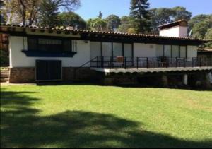 a house with a grass yard in front of it at Casa de Campo, para crear momentos inolvidables! Avandaro, Valle de Bravo in Valle de Bravo
