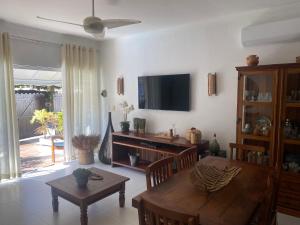 un soggiorno con un tavolo e una TV di Casa Juquehy a São Sebastião