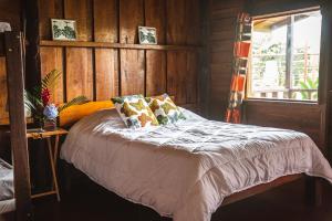 Tres EquisにあるPacuare Mountain Lodgeの木製の壁のドミトリールームのベッド1台分です。