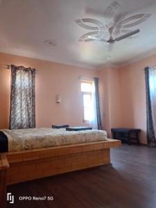 a bedroom with a bed and a ceiling fan at Moonshine Home stay in Srinagar