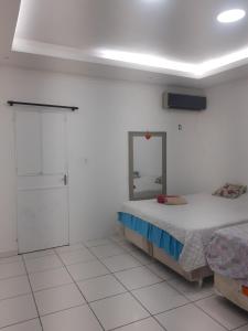 a white room with a bed and a mirror at Hotel SIMPLE in Manaus