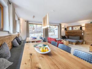 a living room with a wooden table with a bowl of fruit at Burglodge Fischerkeusche in Mauterndorf