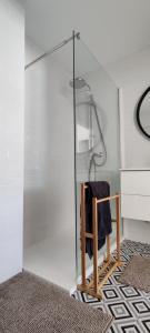 a glass shower stall with a towel on a chair at IAROS Pueblo del Sol in Mogro