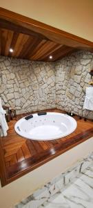 La salle de bains est pourvue d'un lavabo et d'un mur en pierre. dans l'établissement Pousada Vale da Cachoeira, à Visconde de Mauá