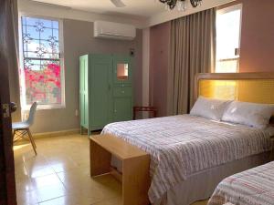 a bedroom with two beds and a green cabinet at Casa Eugenia 35 / Centro Histórico in Campeche