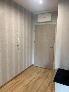 a room with a door and a phone on the wall at APARTAMENT DĘBOWY in Trzcianka
