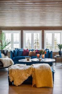 a living room with a blue couch and windows at Toppmoderne hytte i Beito in Beitostøl