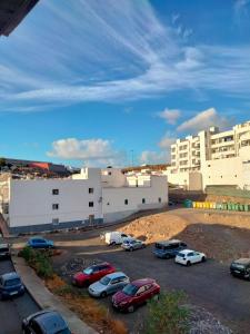 un parking avec des voitures garées devant un bâtiment dans l'établissement Agaete Fray, à Agaete