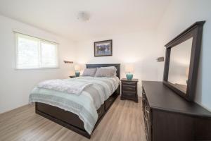 een slaapkamer met een bed, een dressoir en een spiegel bij Bright & Convenient b/w 2 Parks in Steinbach