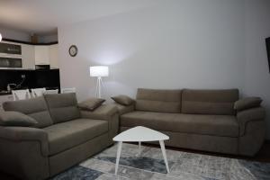 uma sala de estar com um sofá e uma mesa em Prima Guesthouse em Pogradec