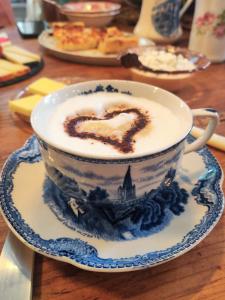 une tasse de cappuccino avec un cœur en mousse dans l'établissement Bed and Breakfast Wildrose, à Berne