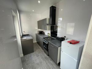 uma pequena cozinha com um fogão e um frigorífico em 38 Gloucester street by Prestige Properties SA em Roose