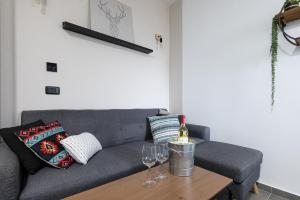 a living room with a couch and wine glasses on a table at Nirvana 1BR Apt, Central Old Town, Private Balcony in Beer Sheva