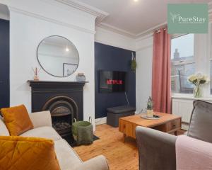 ein Wohnzimmer mit einem Kamin und einem Spiegel in der Unterkunft Stunning Four Bedroom House By PureStay Short Lets & Serviced Accommodation Bradford With Parking in Bradford