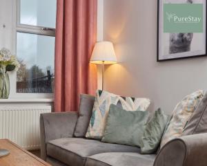 ein Wohnzimmer mit einem Sofa und einem Fenster in der Unterkunft Stunning Four Bedroom House By PureStay Short Lets & Serviced Accommodation Bradford With Parking in Bradford