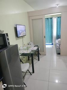 Sea Residences Tower E&B - AURUM في مانيلا: غرفة معيشة مع طاولة وتلفزيون