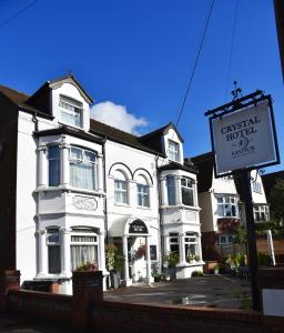 a white building with a sign in front of it at Crystal Hotel & Savour in Cambridge